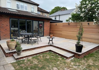 Sandstone patio with a slatted cedar fence